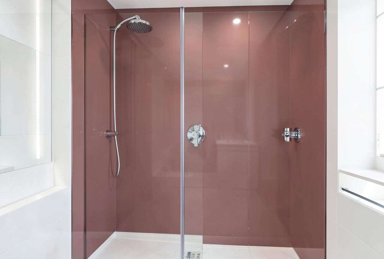 Walk-in shower with soft dusty rose seamless acrylic wall panels and chrome fixtures