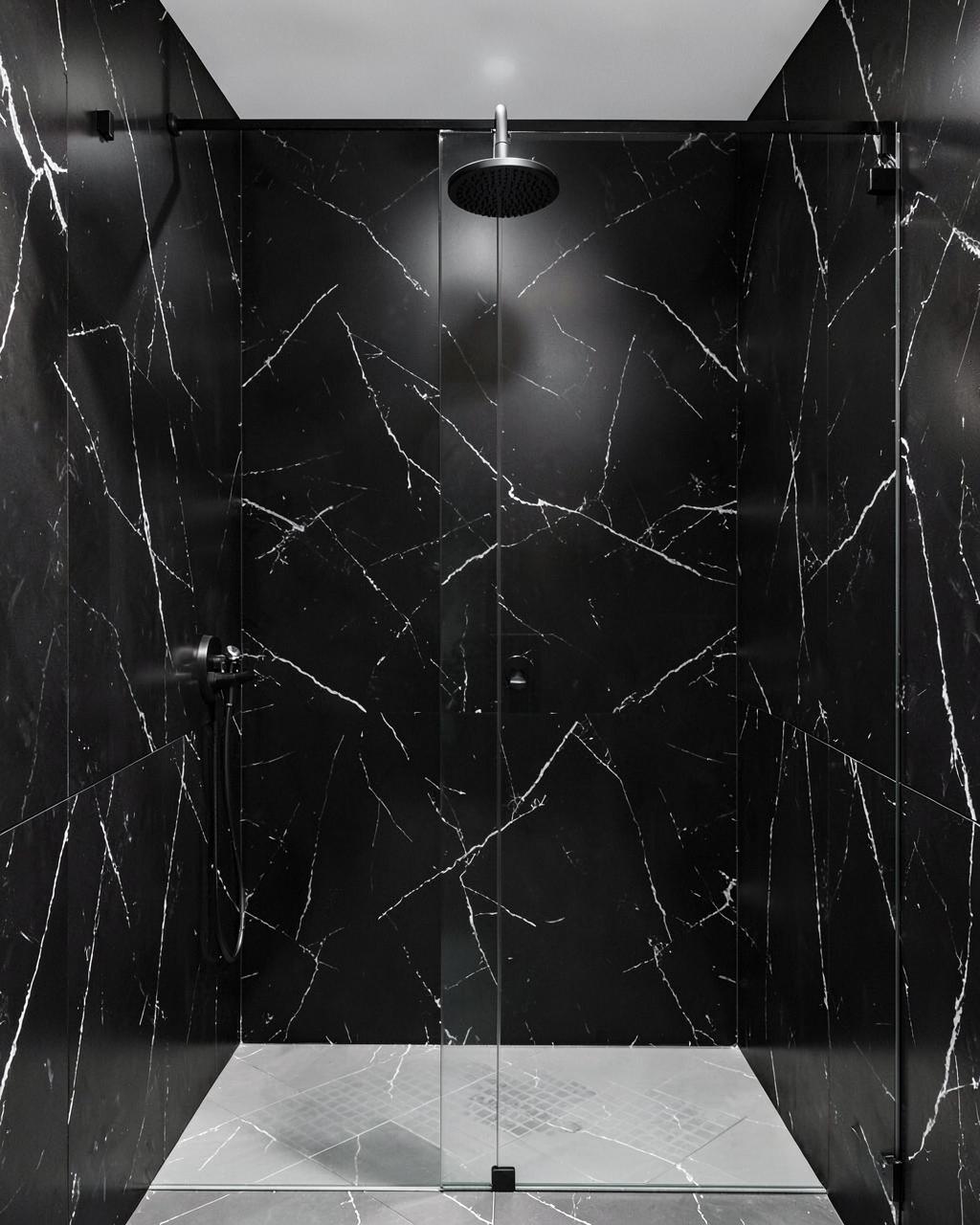 Dramatic shower with dark charcoal marble-look acrylic wall panels and black fixtures