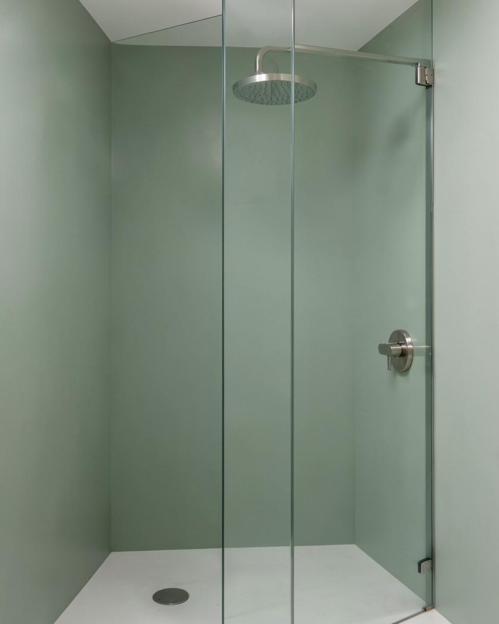 Tub and shower combo with solid sage green acrylic wall panels and brass fixtures